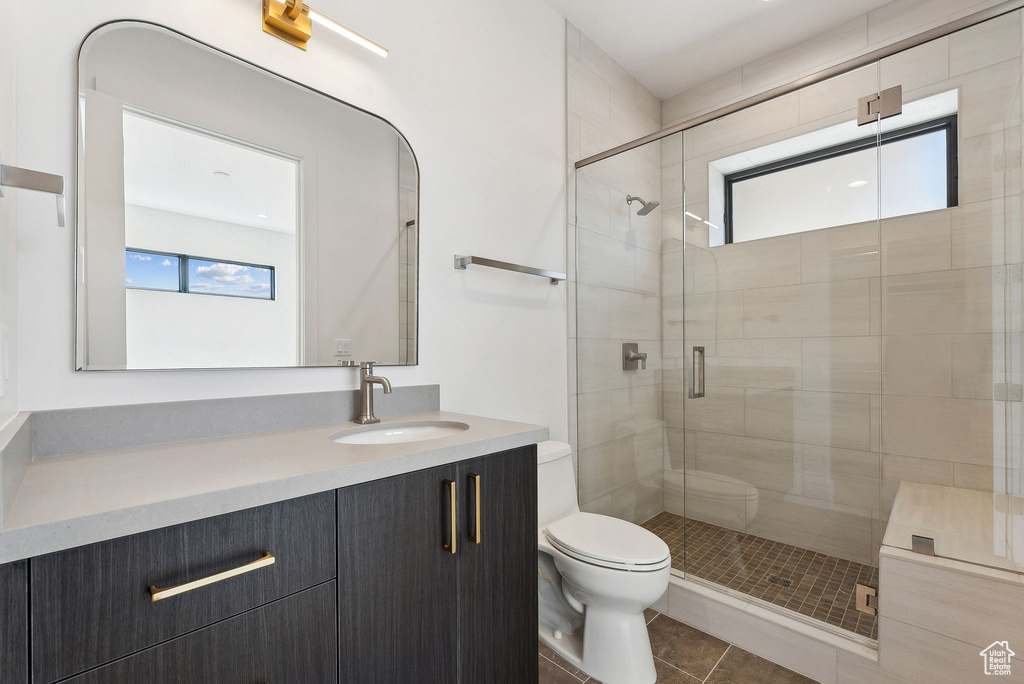 Bathroom with tile patterned flooring, vanity, toilet, and an enclosed shower