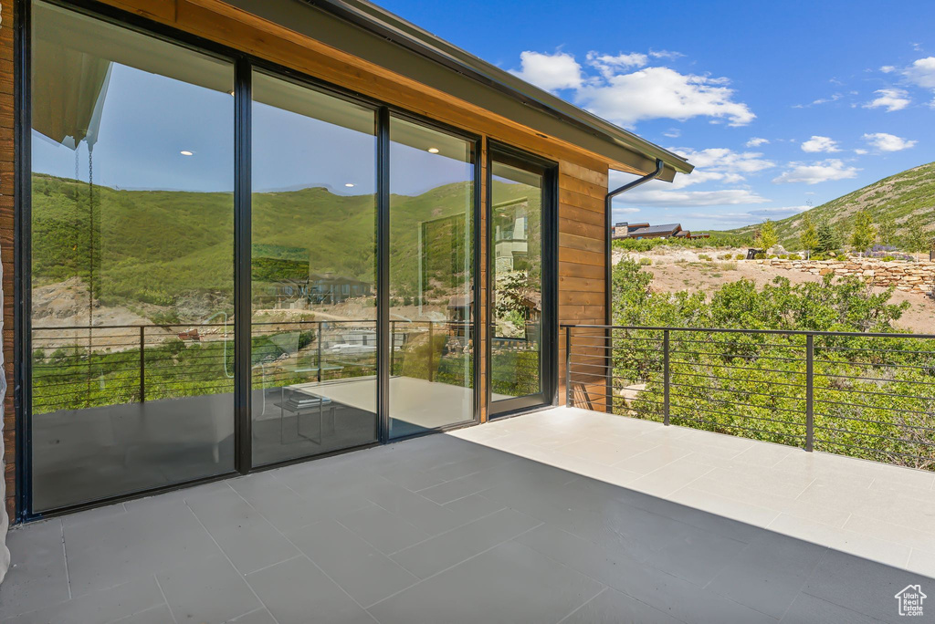 Doorway with a healthy amount of sunlight, a mountain view, and tile patterned floors