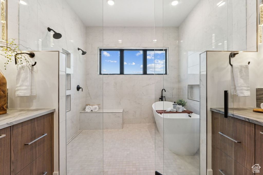 Bathroom featuring vanity and independent shower and bath