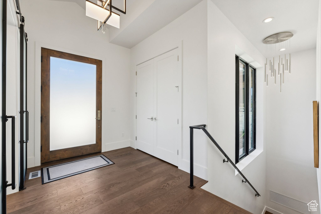 Entryway with a barn door and dark hardwood / wood-style floors