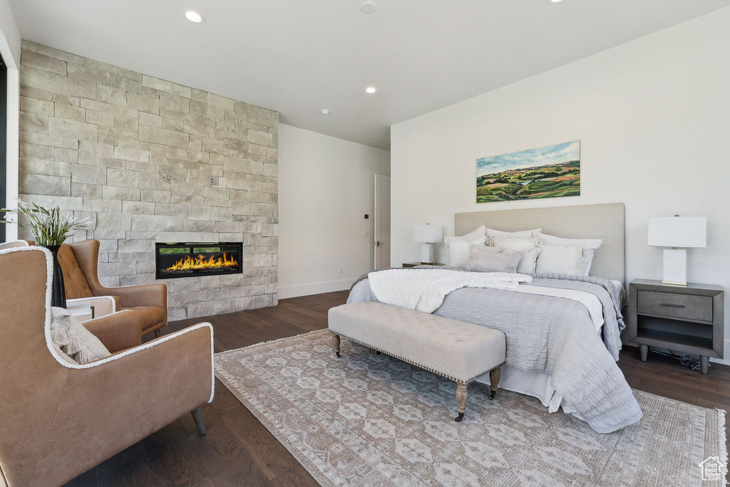 Bedroom with dark hardwood / wood-style flooring and a fireplace