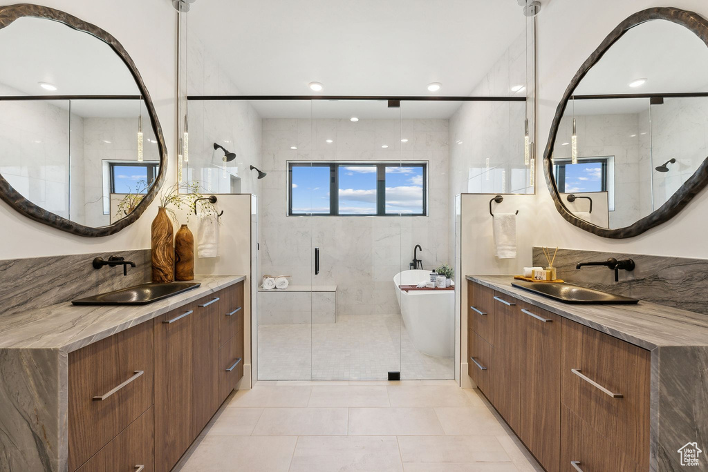 Bathroom featuring tile patterned flooring, vanity, and shower with separate bathtub