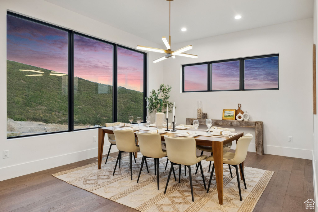 Dining space with hardwood / wood-style floors and a notable chandelier