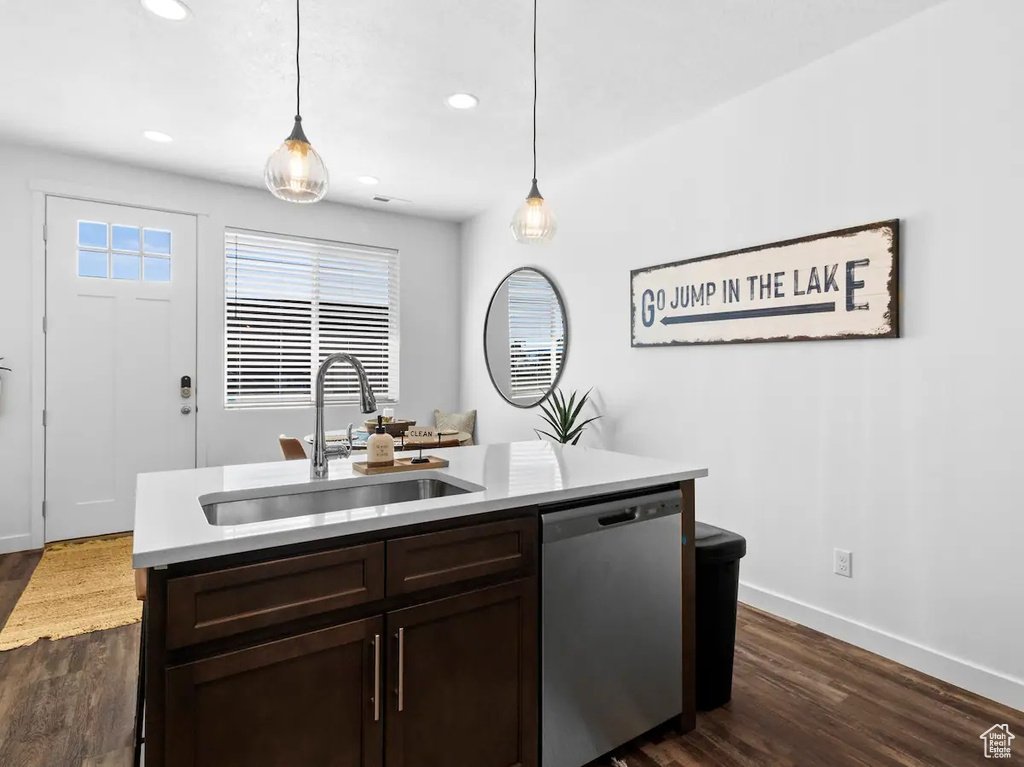 Kitchen featuring hanging light fixtures, sink, dishwasher, and dark hardwood / wood-style flooring