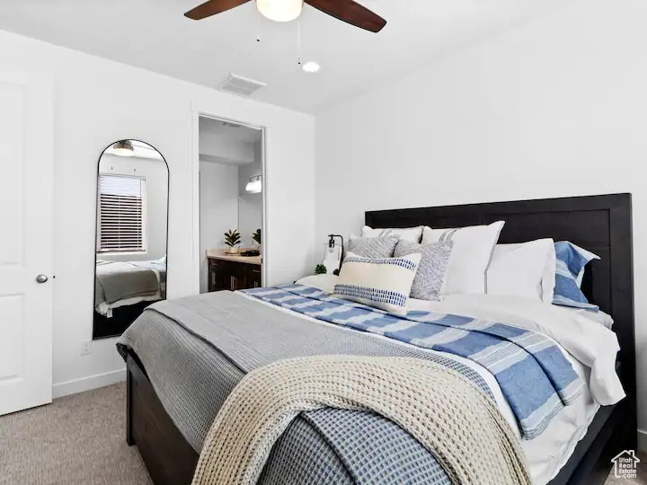 Bedroom featuring carpet flooring, ensuite bathroom, and ceiling fan