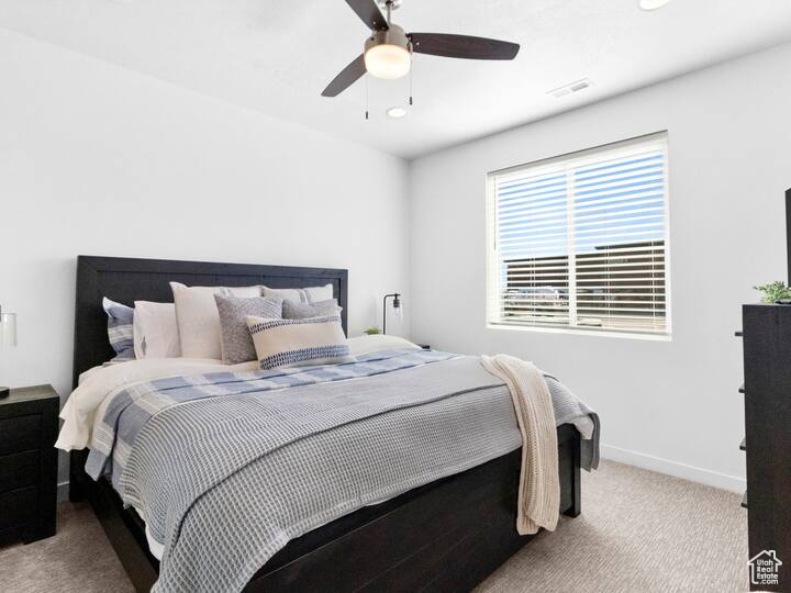 Carpeted bedroom with ceiling fan