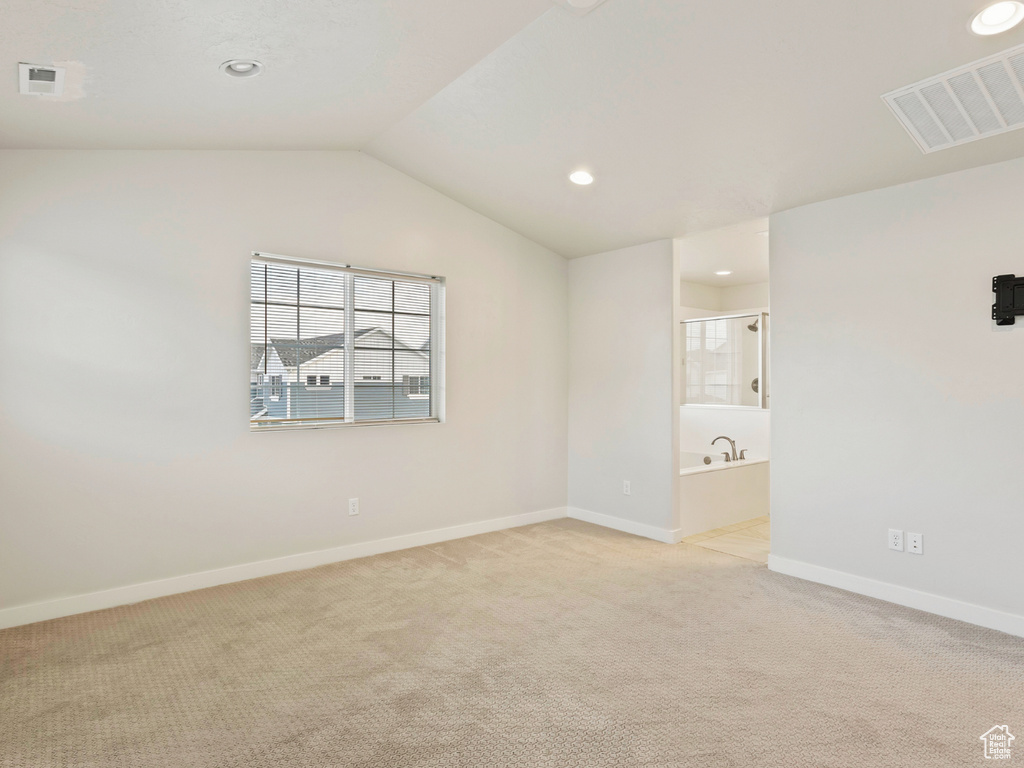 Interior space with light carpet and lofted ceiling