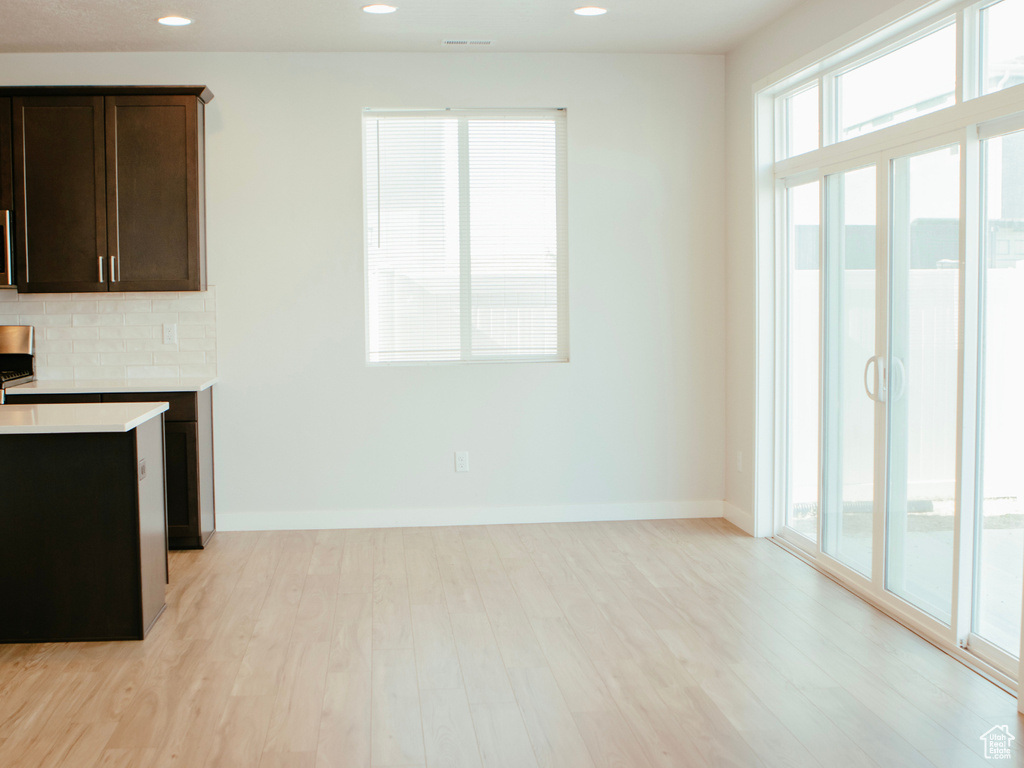 Interior space with backsplash, light wood-type flooring, and dark brown cabinetry