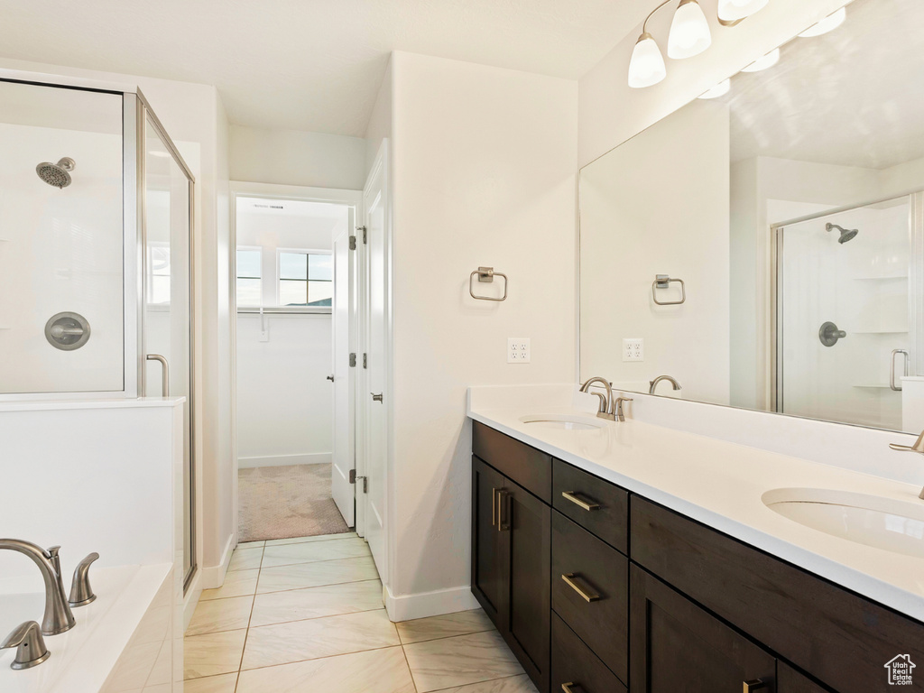 Bathroom with double vanity, walk in shower, and tile floors