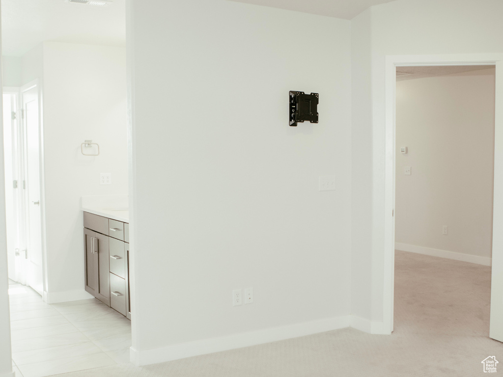 Hallway featuring light colored carpet