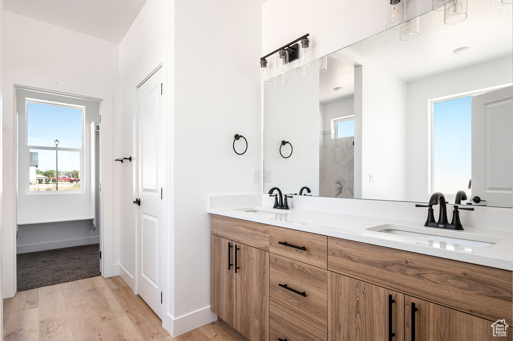 Bathroom with hardwood / wood-style flooring and double sink vanity