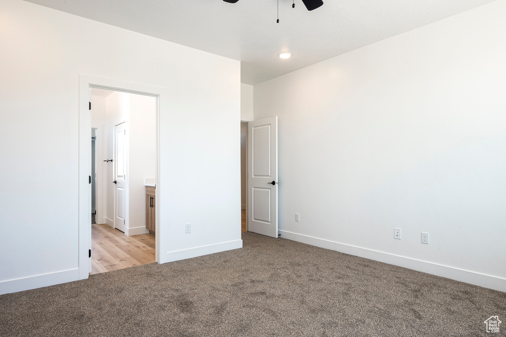 Unfurnished bedroom with ceiling fan and light carpet