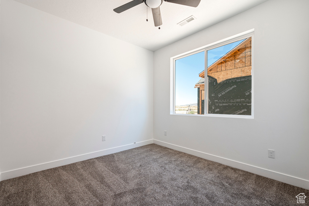 Empty room with carpet and ceiling fan