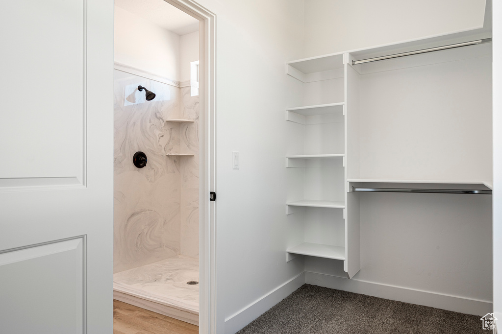 Interior space with a tile shower and wood-type flooring