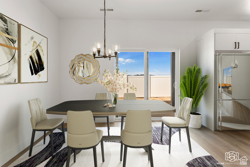 Dining space with light wood-type flooring and a chandelier