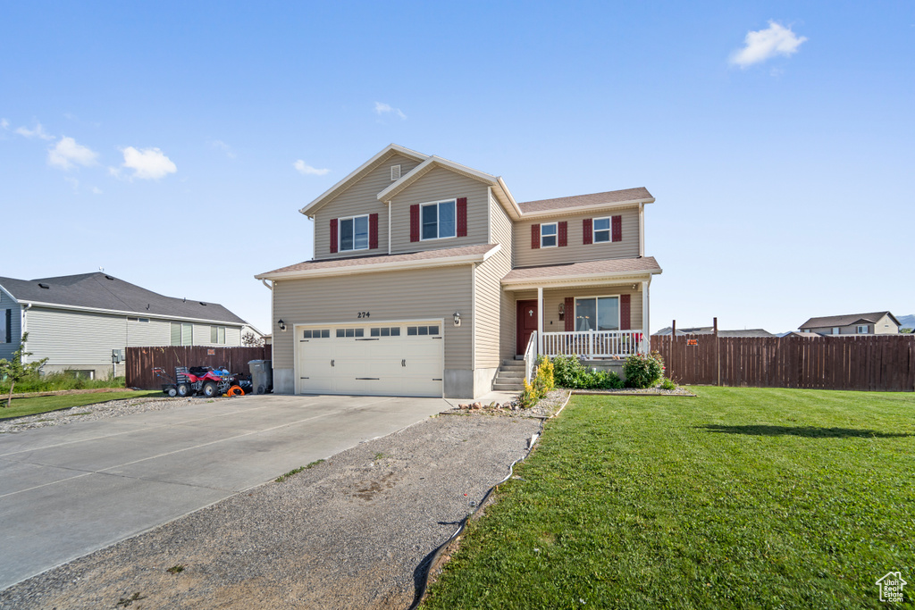 Front of property with a garage, a front lawn, and a porch