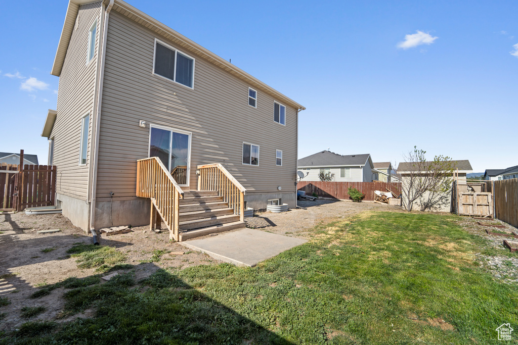 Rear view of property featuring a patio area, a shed, and a lawn