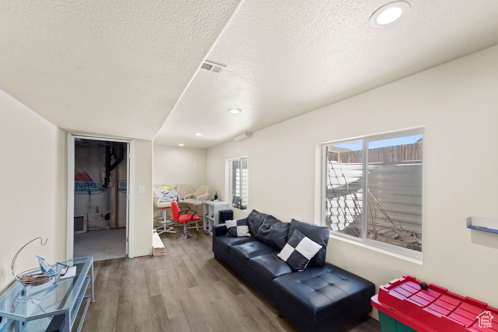 Living room with a textured ceiling and hardwood / wood-style floors