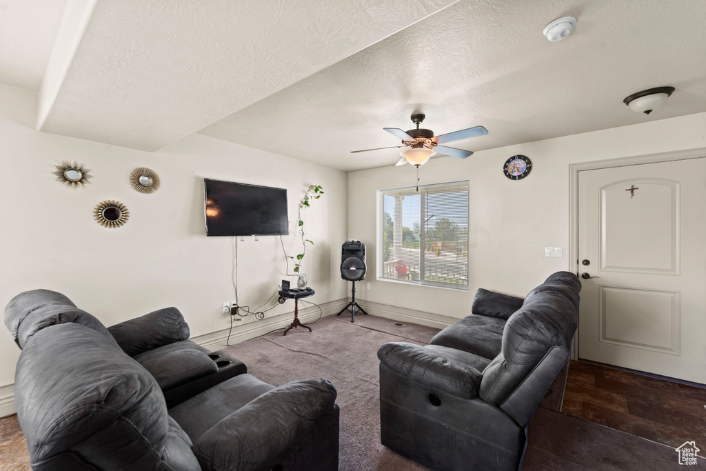 Living room featuring tile floors, ceiling fan, and a textured ceiling