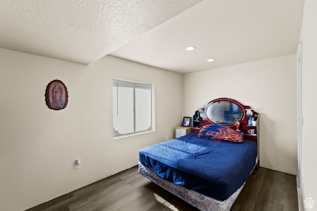 Bedroom featuring dark hardwood / wood-style flooring and a textured ceiling