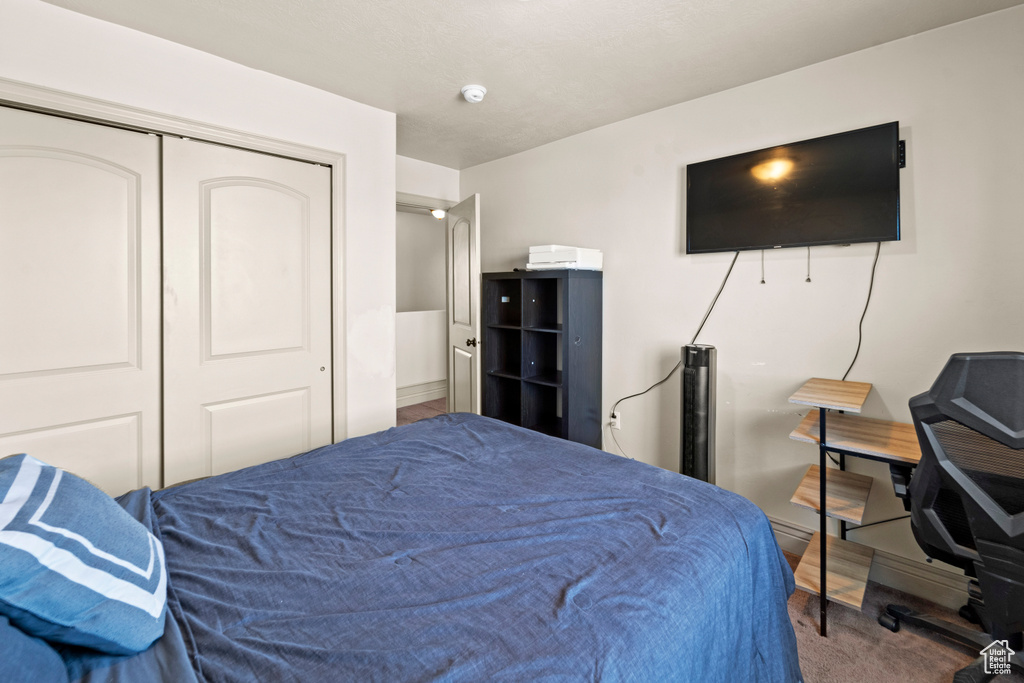 Bedroom featuring carpet flooring and a closet