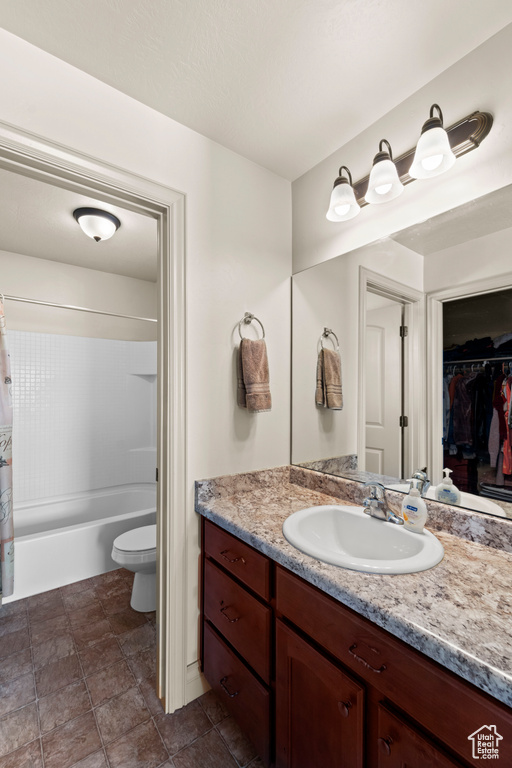 Full bathroom featuring tile floors, shower / bath combo, toilet, and large vanity