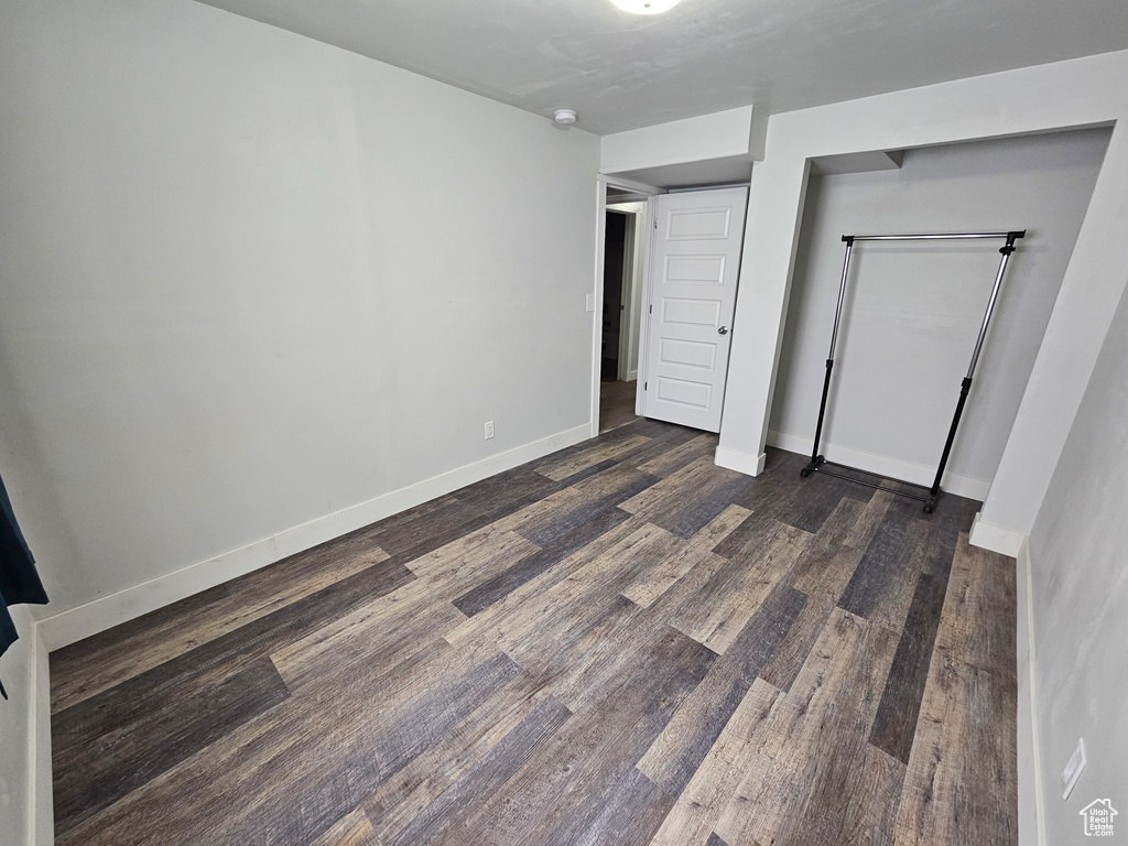 Unfurnished bedroom with dark hardwood / wood-style floors