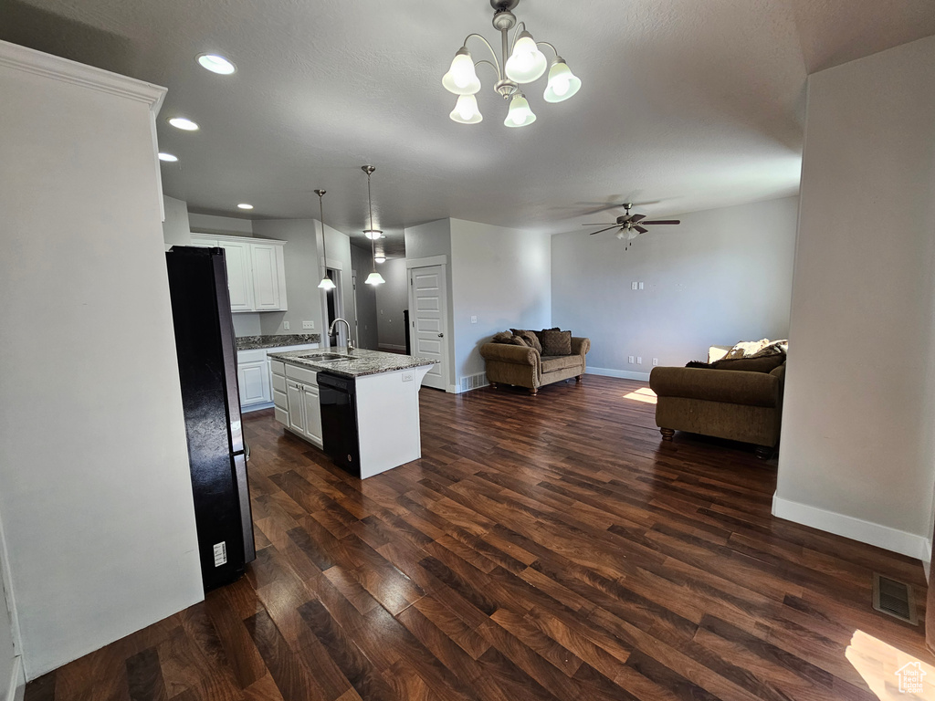 Kitchen with dark hardwood / wood-style floors, decorative light fixtures, white cabinetry, and black appliances