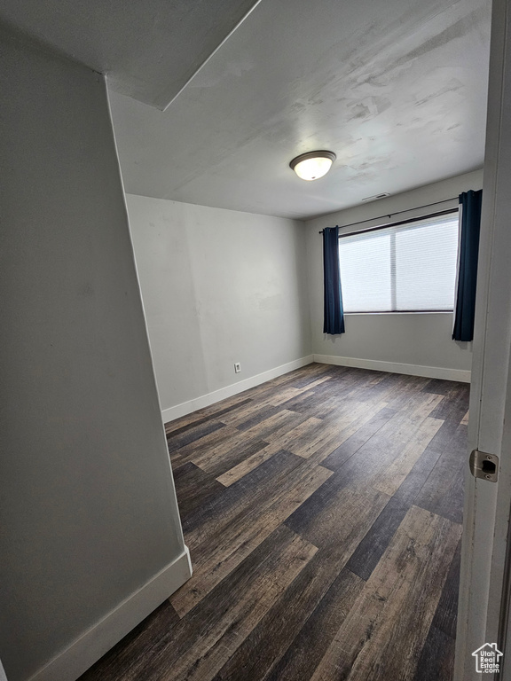 Empty room with dark hardwood / wood-style flooring