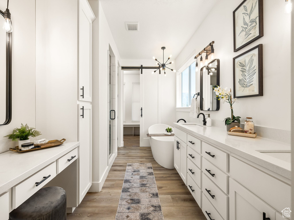 Bathroom with a bath, hardwood / wood-style floors, and double vanity