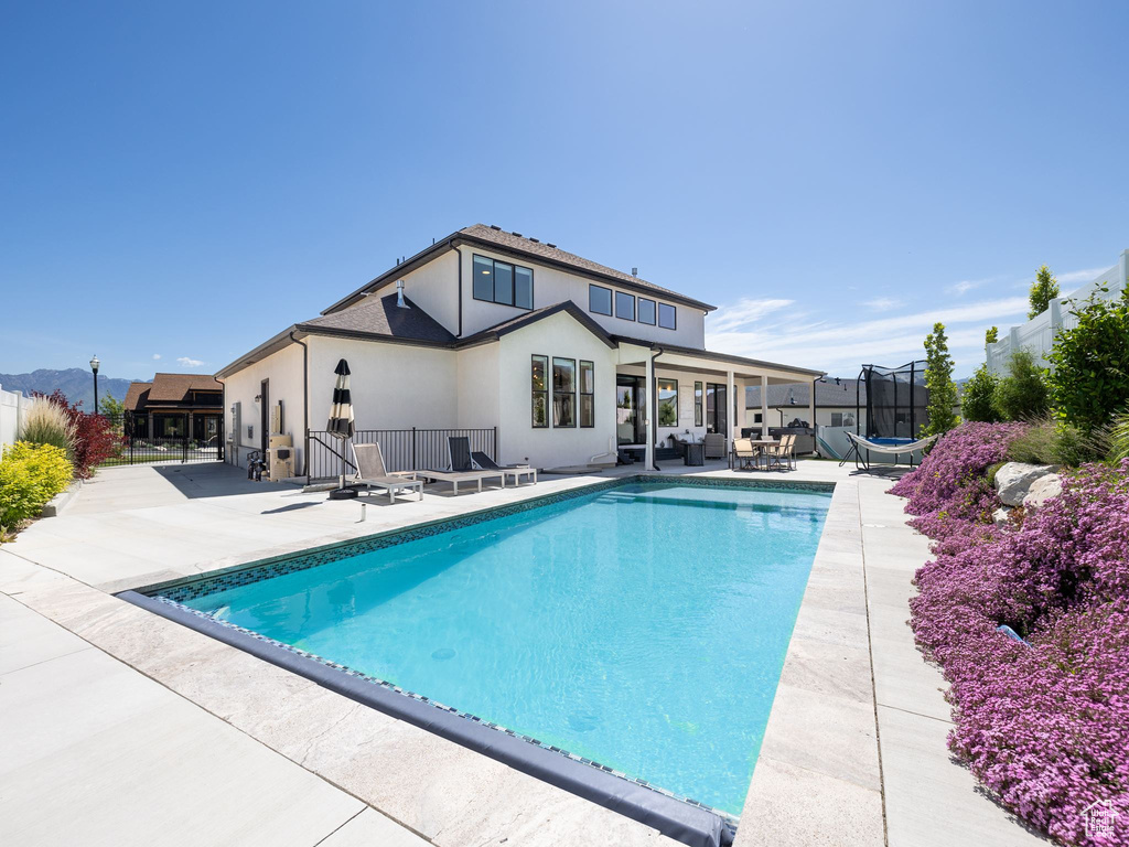 View of swimming pool with a patio and a trampoline