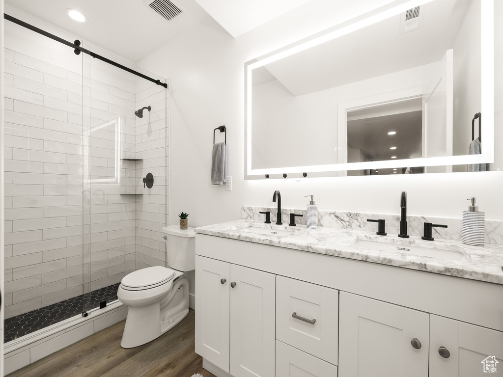 Bathroom with walk in shower, dual bowl vanity, hardwood / wood-style flooring, and toilet