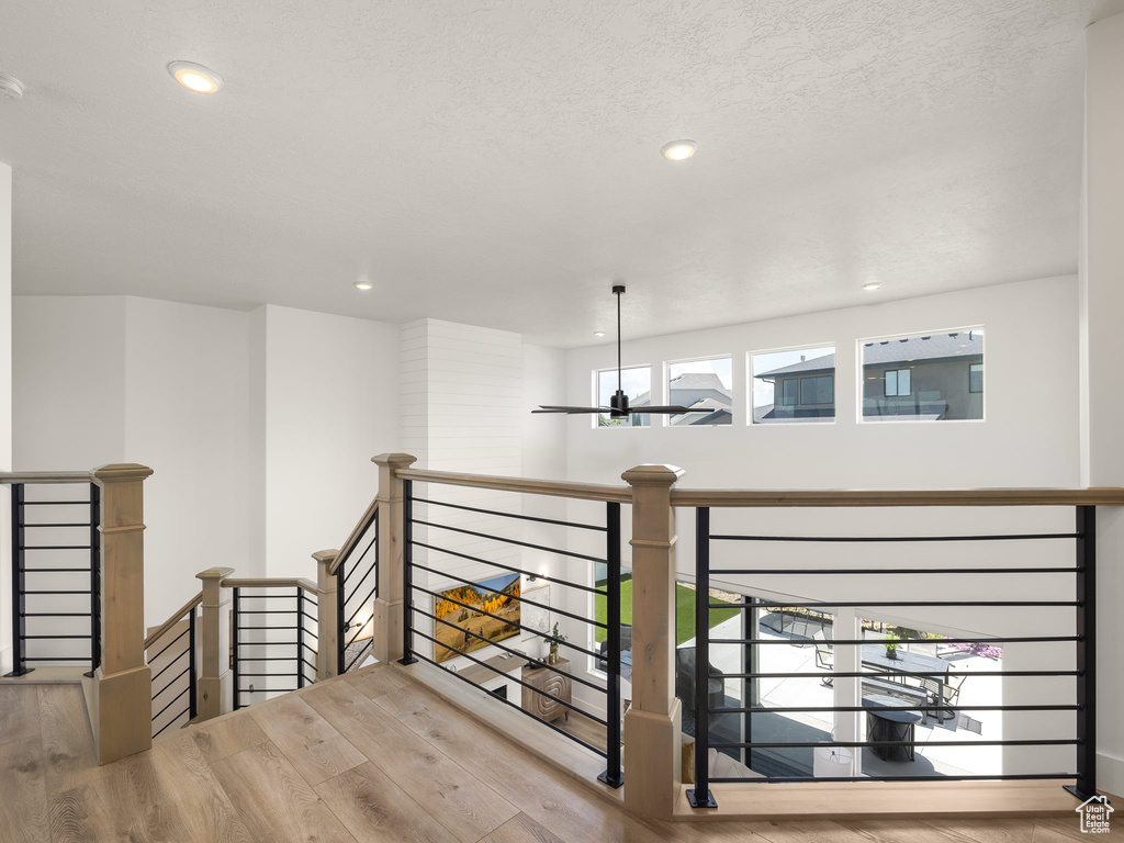 Staircase featuring a textured ceiling and hardwood / wood-style floors