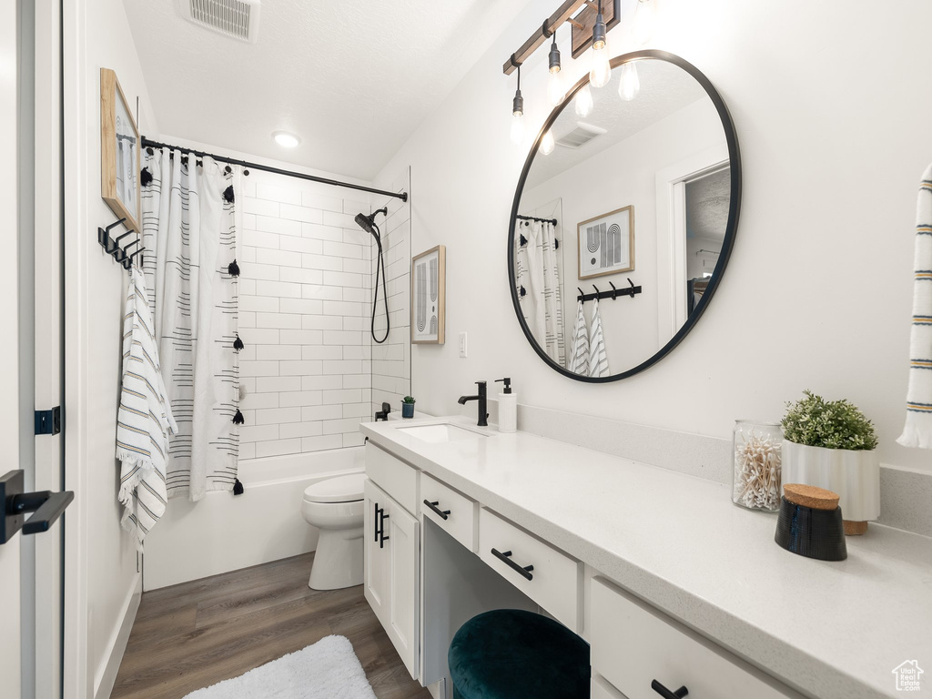 Full bathroom with shower / tub combo with curtain, hardwood / wood-style flooring, toilet, and vanity