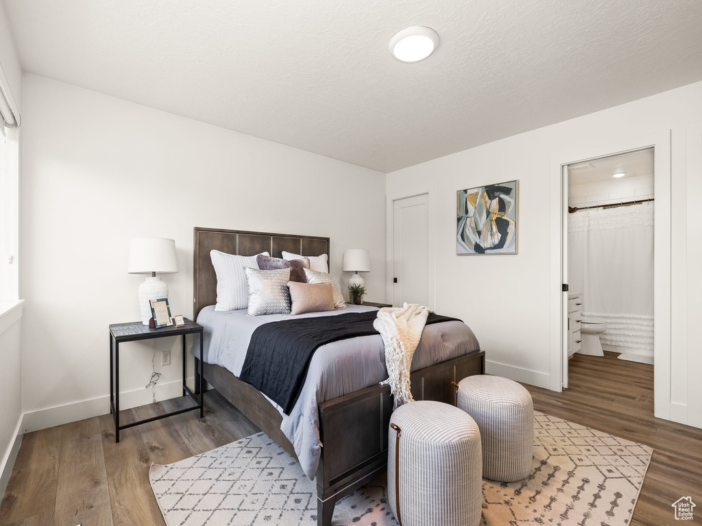 Bedroom featuring hardwood / wood-style flooring and ensuite bathroom