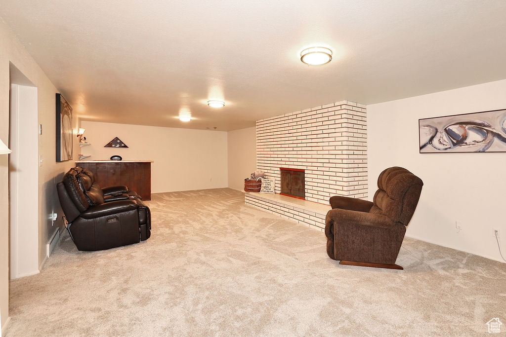 Sitting room with carpet floors, brick wall, and a brick fireplace