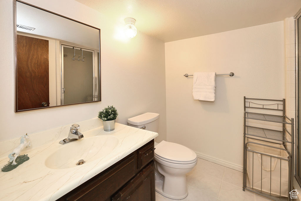 Bathroom with tile flooring, vanity, and toilet