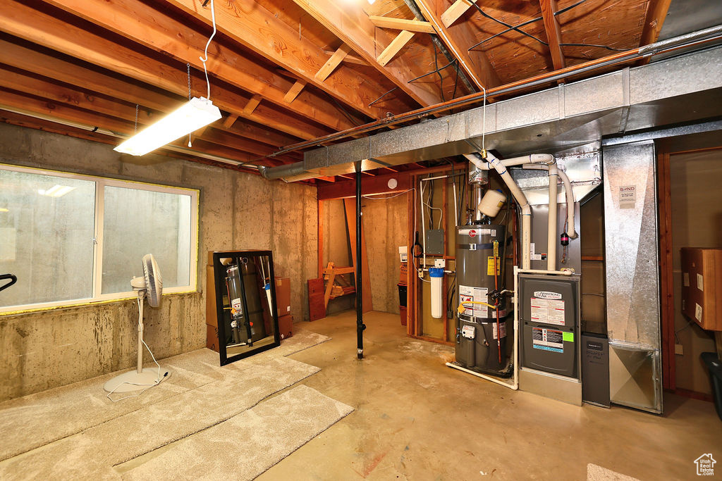 Basement featuring strapped water heater