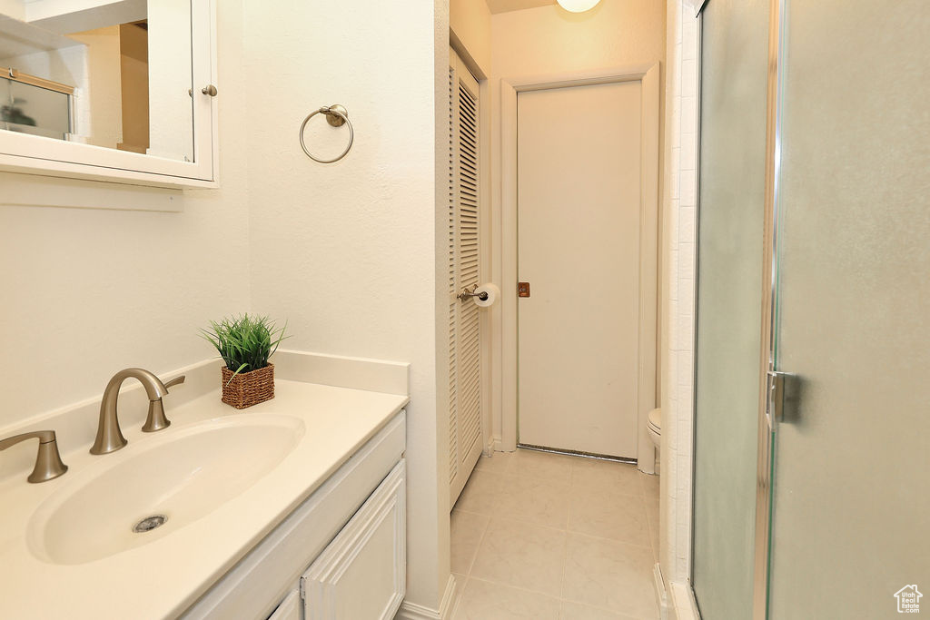 Bathroom featuring tile flooring, vanity, and toilet