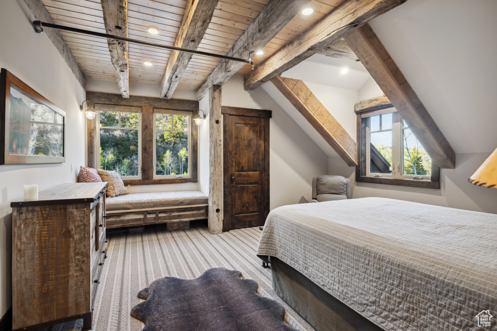 Carpeted bedroom with beam ceiling, multiple windows, and wood ceiling