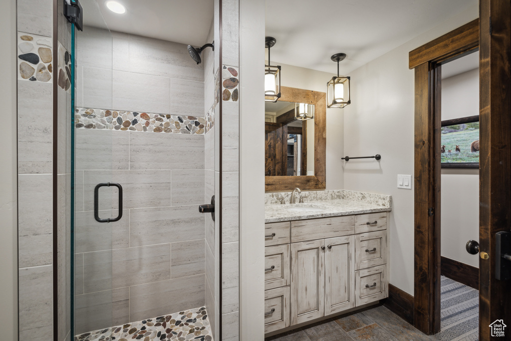 Bathroom featuring a shower with shower door and oversized vanity