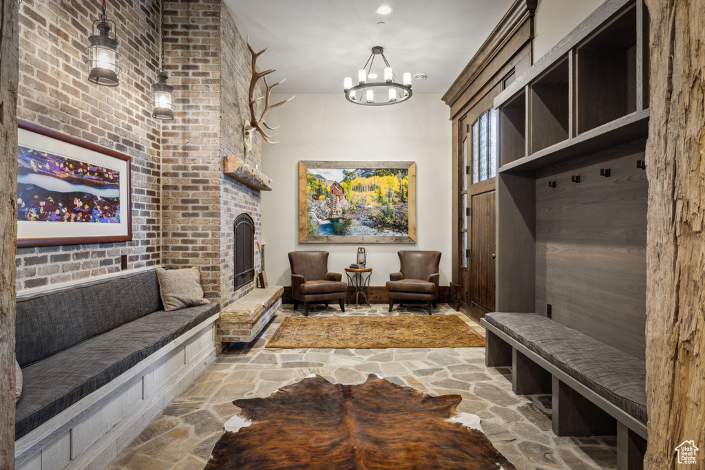 Mudroom with brick wall and an inviting chandelier