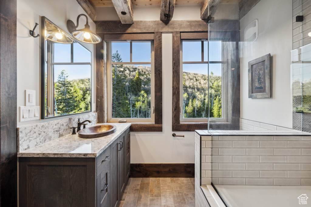 Bathroom with beamed ceiling, a chandelier, hardwood / wood-style flooring, and large vanity