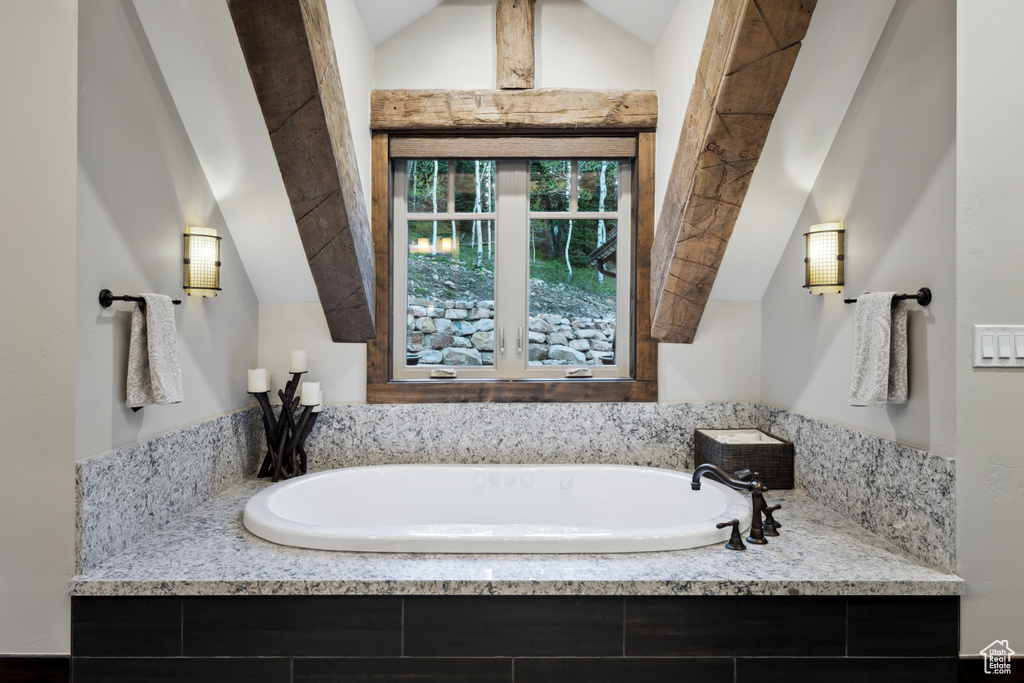 Bathroom with lofted ceiling and tiled tub