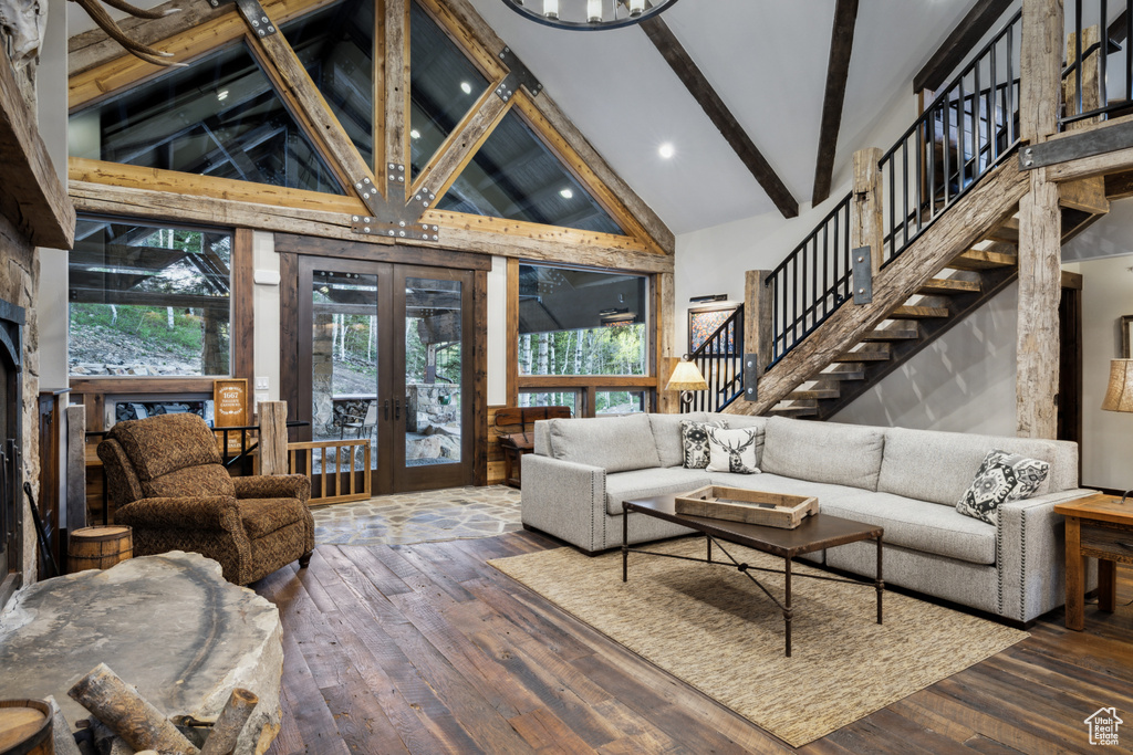 Living room featuring high vaulted ceiling, hardwood / wood-style floors, french doors, and a healthy amount of sunlight