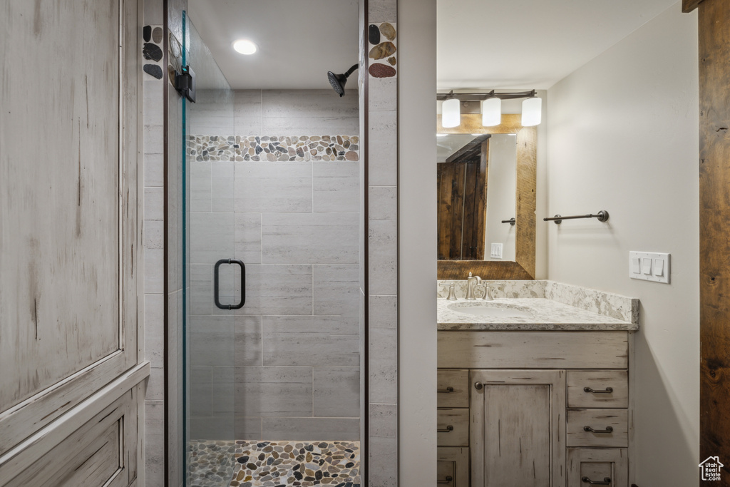 Bathroom featuring oversized vanity and a shower with door