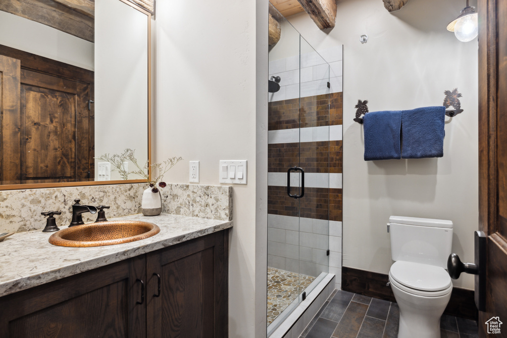 Bathroom with tile floors, an enclosed shower, vanity, and toilet