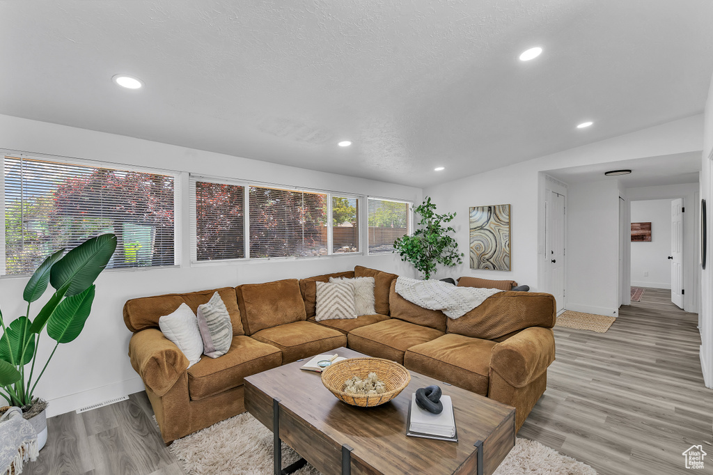 Living room with vaulted ceiling and hardwood / wood-style flooring