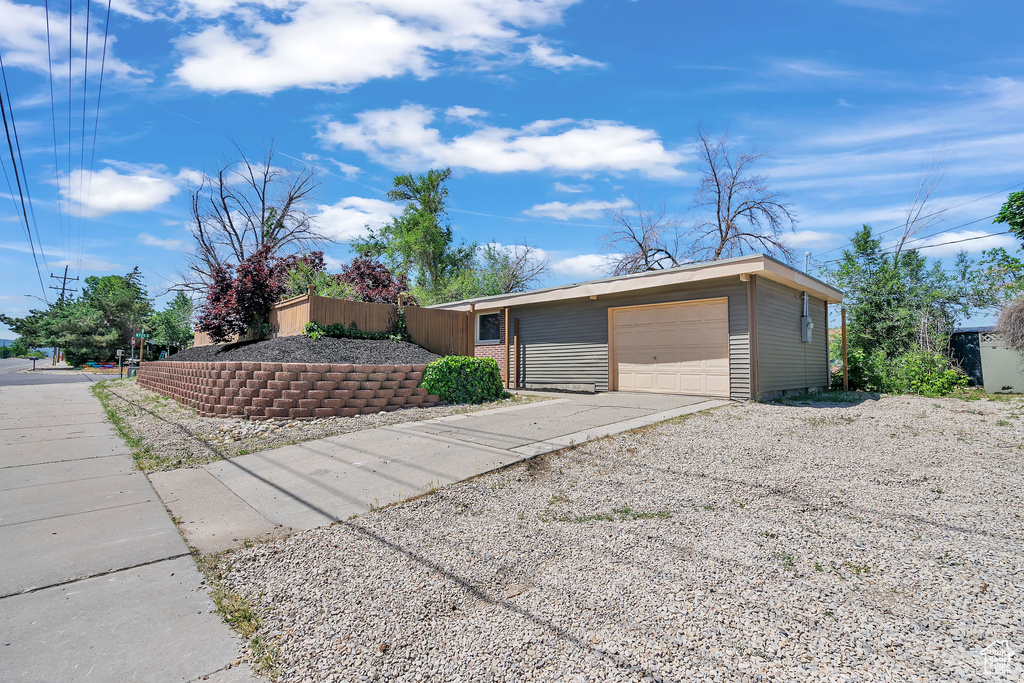 View of front of home with a garage and an outdoor structure