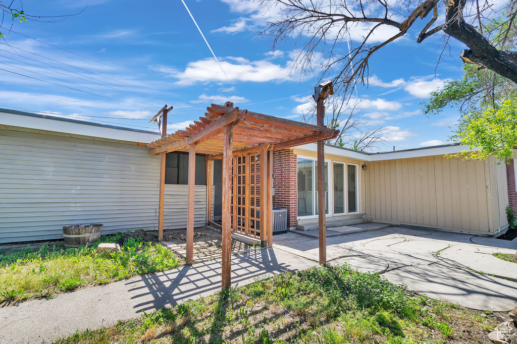 Rear view of house featuring a pergola and a patio area